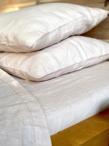 poduszki, fragment kołdry i prześcieradło lniane w kolorze beżowego różu