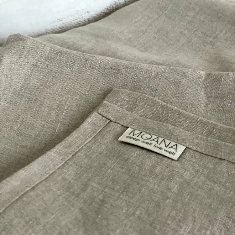 fragment lnianego prześcieradła w kolorze naturalnym z metką MOANA