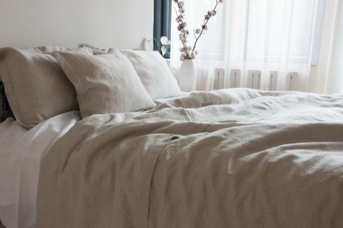 Lniana pościel beżowa z ozdobną plisą w połączeniu z białym lnianym prześcieradłem