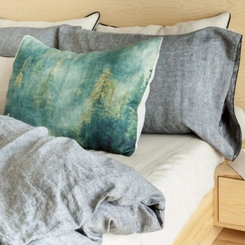 lniana poduszka z nadrukiem lasu zestawiona z szarą i białą pościelą