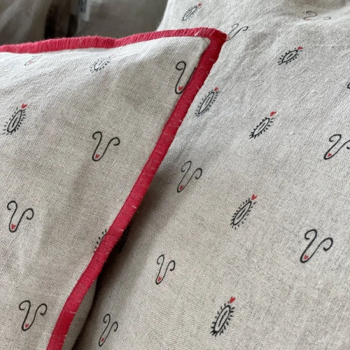 Lniana poszewka na poduszkę z nadrukowanym motywem miłosnym. Detal - czerwone obszycie