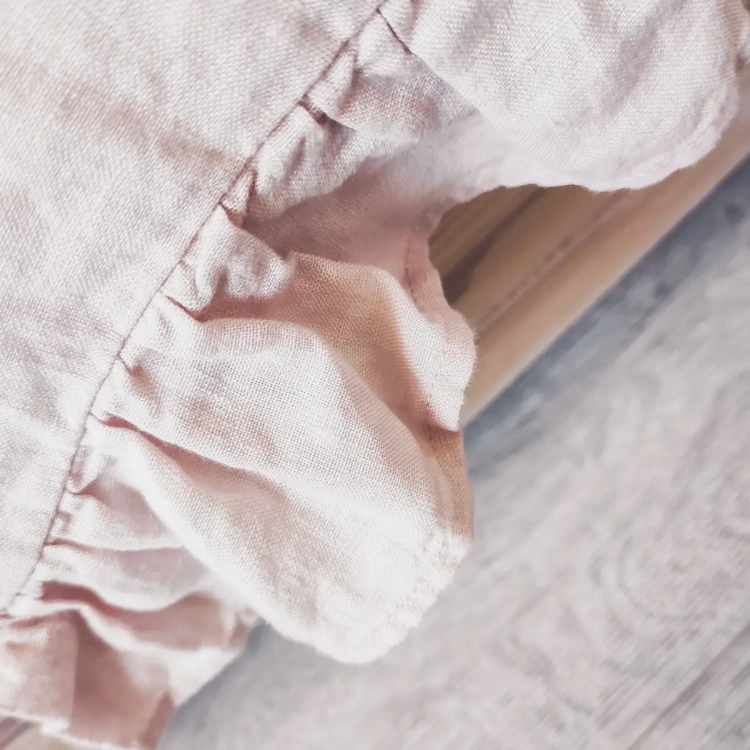 Lniana poszewka na poduszkę z falbankami różowa. Detal - szeroka falbana na bokach