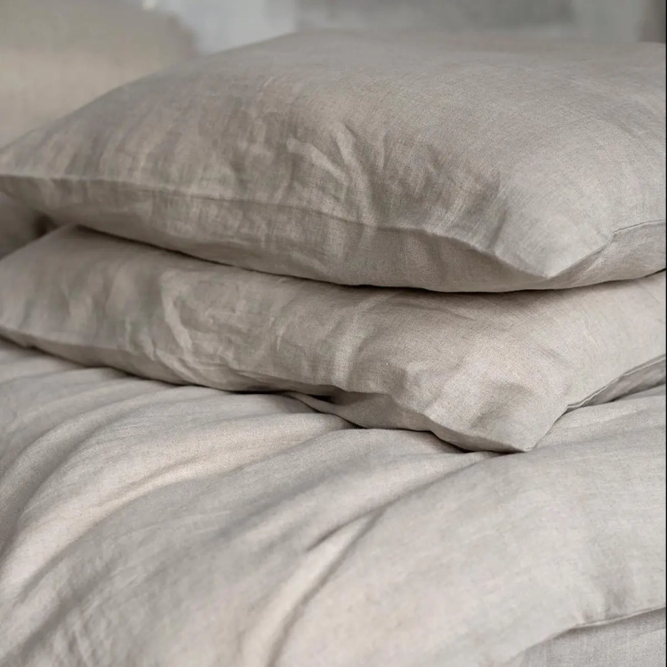 dwie poduszki leżące na kołdrze z lnu naturalnego