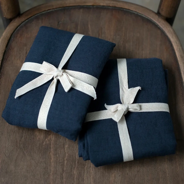 Lniana pościel granatowa BASIC navy blue złożona, przewiązana ozdobną bawełnianą tasiemką