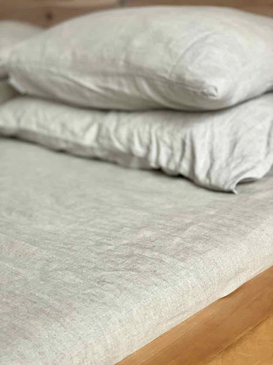 Lniane prześcieradło z gumką natural szaro beżowe
Fragment łóżka drewnianego z lnianą pościelą w kolorze naturalnym