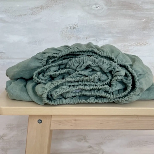 Lniane prześcieradło zielone PURE eucalyptus green.
Zielone lniane eukaliptusowe prześcieradło z gumką leży na ławie