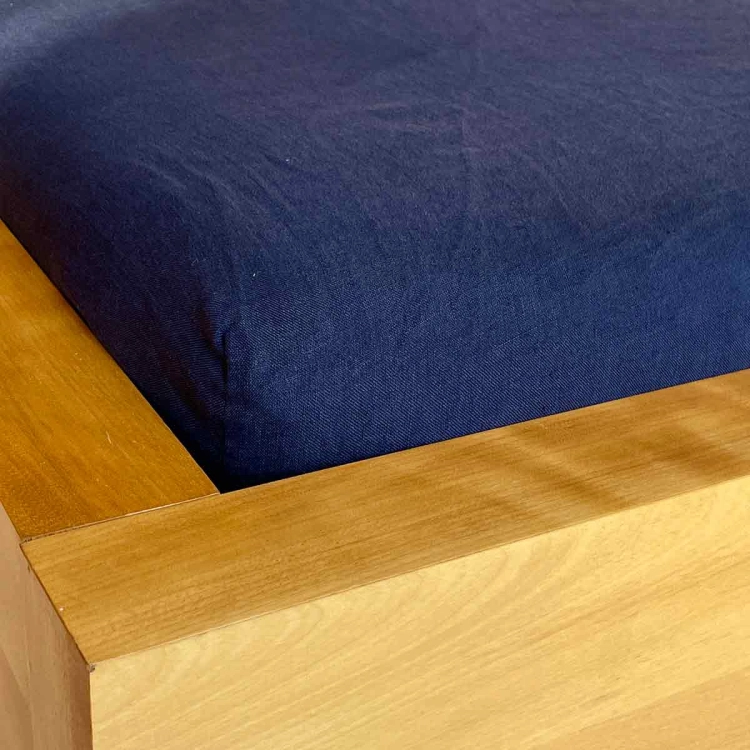 Lniane prześcieradło z gumką granatowe navy blue
Narożnik materaca pościelonego granatowym prześcieradłem lnianym