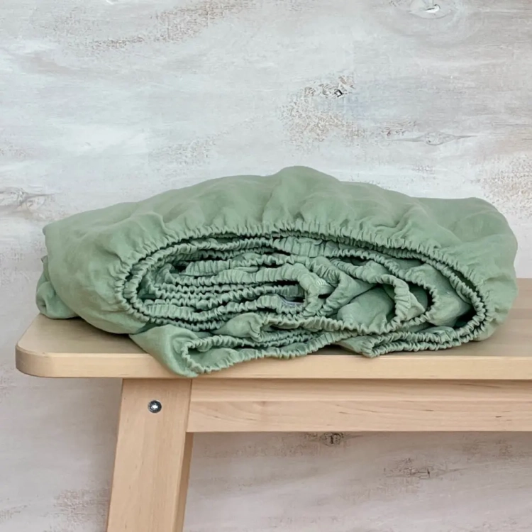 Lniane prześcieradło z gumką zielone PURE sage green
jasnozielone lniane prześcieradło z gumką, zwinięte, leży na drewnianym stole