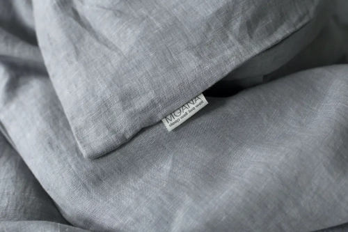 poszewka lniana szara SILVER BIRCH. Detal, struktura melanżu, metka z logo marki MOANA