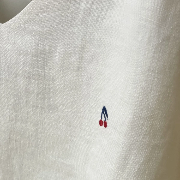 Haftowane wisienki. Biały lniany top z kolekcji CHERRY - detal