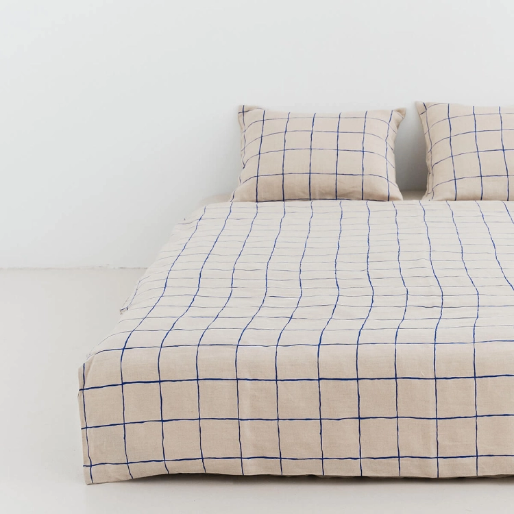 ByMoana23.118956.jpg Lniana pościel naturalna w granatową kartę leży na łóżku