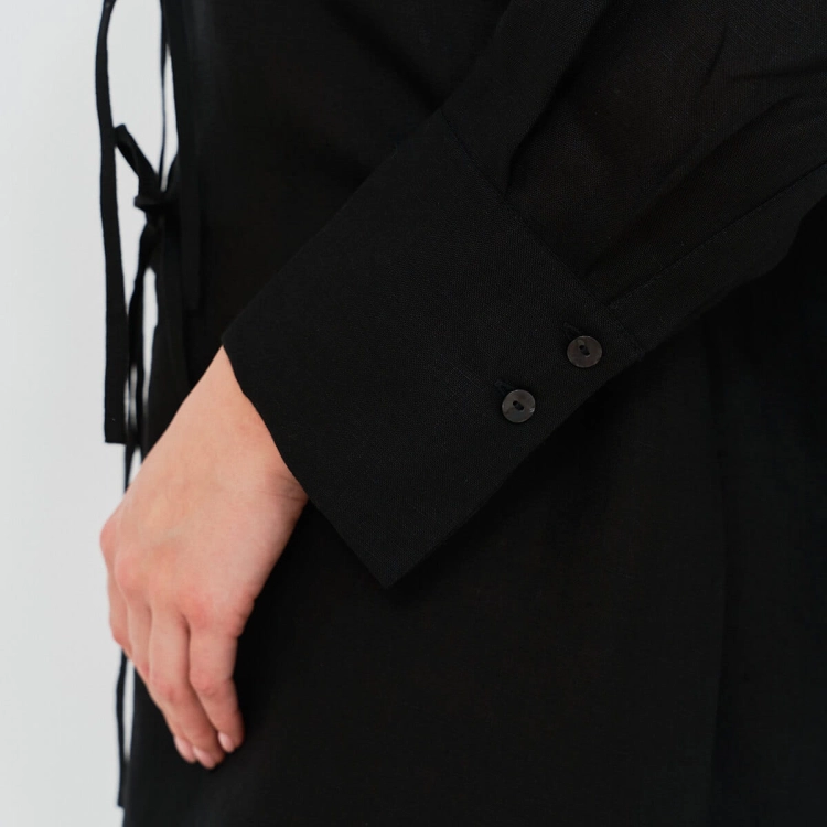 Czarna lniana tunika. Wiązane kokardki na przodzie. Mankiet rękawa zapinany na dwa guziki