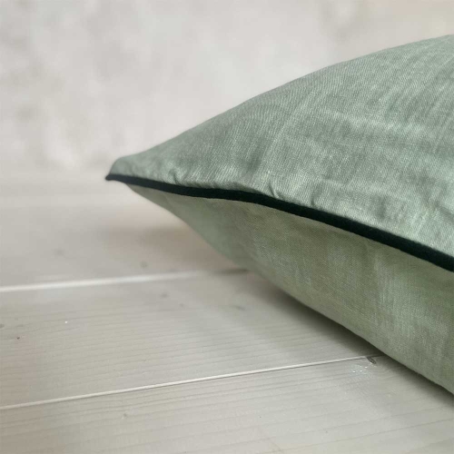 lniana poszewka na poduszkę w kolorze jasnej zieleni z ozdobnymi czarnymi wypustkami