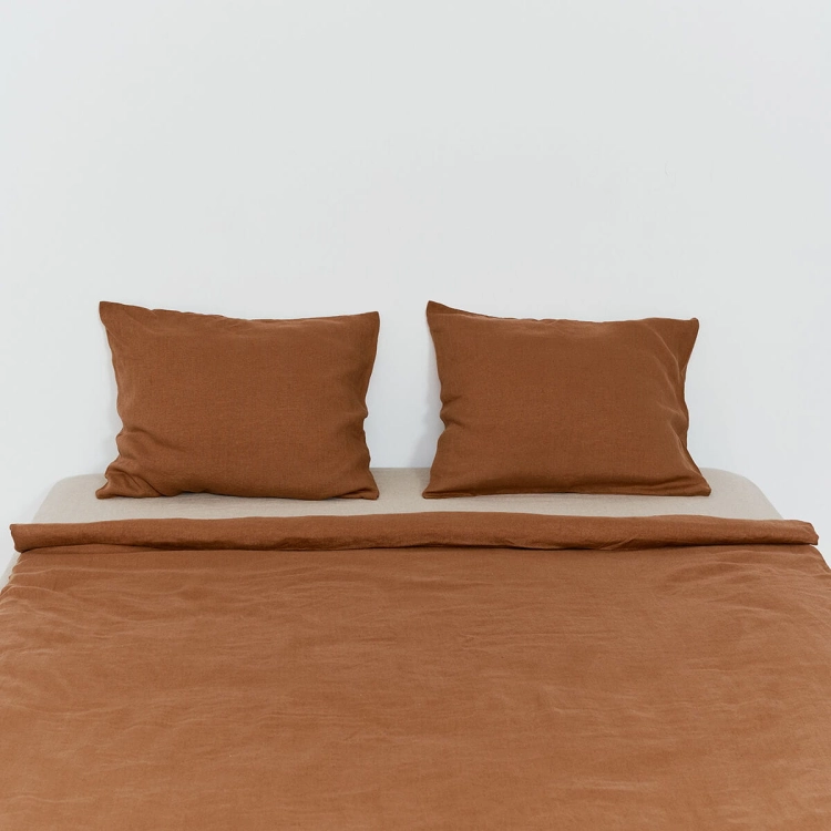 Poduszki i fragment lnianej kołdry w kolorze cynamonowym brązowym