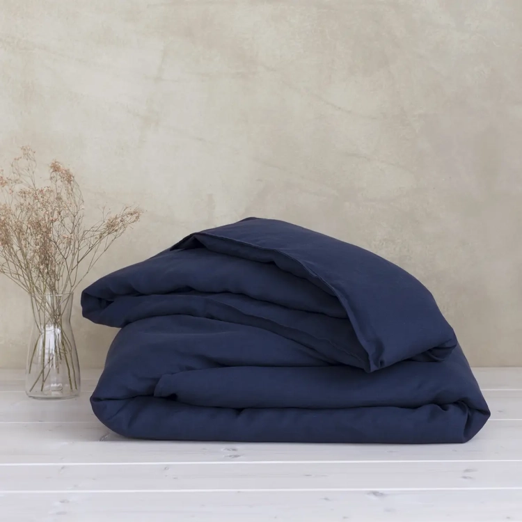 złożona kołdra w granatowej poszewce z naturalnego lnu