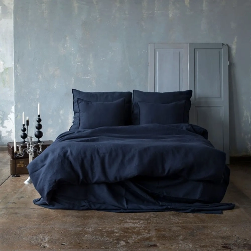 granatowa ciemna pościel na dużym podwójnym łóżku, pomieszczenie w stylu bohoaranżacja