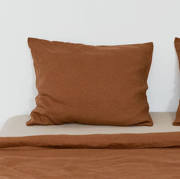 fragment pościeli lnianej w kolorze cynamonowego brązu, poduszka, fragment kołdry